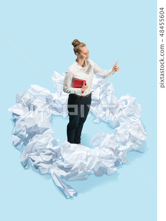 Concept of a new idea. A woman and crumpled pieces of paper Concept of a new idea. A woman and crumpled pieces of paper 48455604