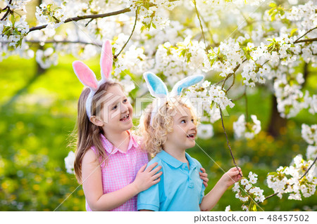 Easter egg hunt. Kids with bunny ears and basket. 48457502