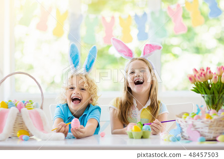 Kids on Easter egg hunt. Children dye eggs. 48457503