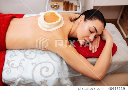 Appealing flawless lady with dark hair affecting her body with Ayurveda procedure Appealing flawless lady with dark hair affecting her body with Ayurveda procedure 48458219