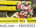 Bride and groom in bright clothes on the bench 48458263