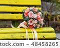 Bride and groom in bright clothes on the bench 48458265