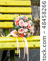 Bride and groom in bright clothes on the bench 48458266