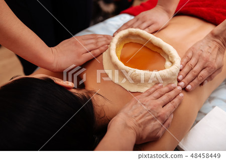 Woman having kati vasti Ayurveda treatment in salon Woman having kati vasti Ayurveda treatment in salon 48458449