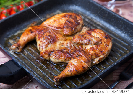 Fried chicken tobacco (tabaka) in a grill pan 48459875