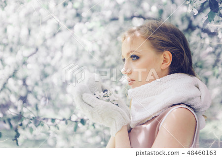 girl in a warm scarf and mittens holding flowers girl in a warm scarf and mittens holding flowers 48460163