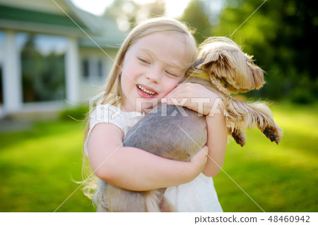 Cute little girl holding her funny yorkshire terrier dog Cute little girl holding her funny yorkshire terrier dog 48460942