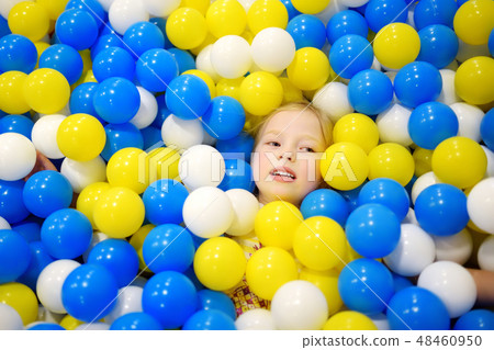 Happy little girl having fun in ball pit Happy little girl having fun in ball pit 48460950
