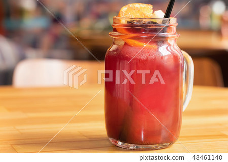 Close up glass jar with hot mulled wine and straw on light wooden table Close up glass jar with hot mulled wine and straw on light wooden table 48461140