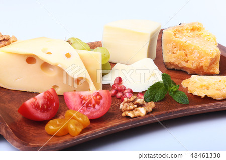 Assortment of cheese with fruits, grapes, nuts and cheese knife on a wooden serving tray. 48461330