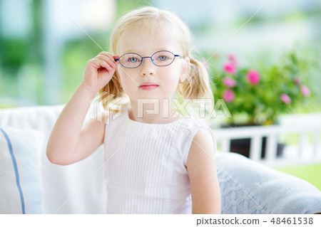 Portrait of beautiful little girl wearing glasses at home Portrait of beautiful little girl wearing glasses at home 48461538