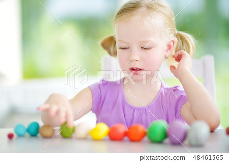 Cute little girl having fun with colorful modeling clay at a daycare Cute little girl having fun with colorful modeling clay at a daycare 48461565