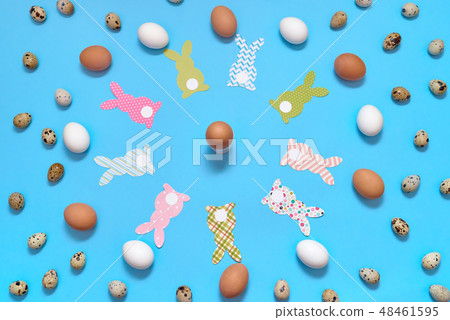 Easter bunny decoration and eggs on blue paper Easter bunny decoration and eggs on blue paper 48461595