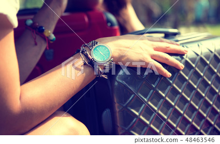 The hand of a young girl traveler on a suitcase waiting for the train 48463546