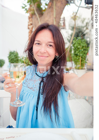 Woman taking selfie sitting in outdoor cafe. Woman taking selfie sitting in outdoor cafe. 48463632