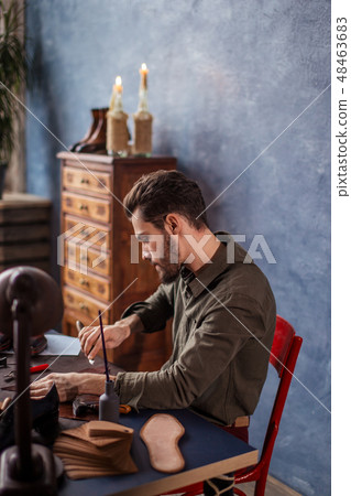 close up back view photo.guy tailoring shoes at his desk at home 48463683