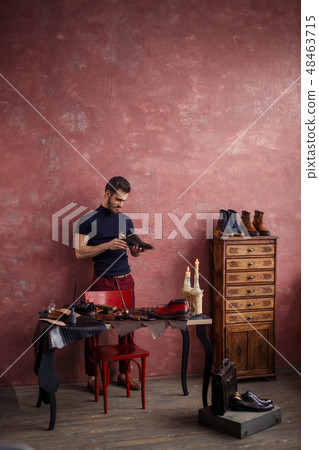 young bearded man is happy as he has repaired the old shoes 48463715