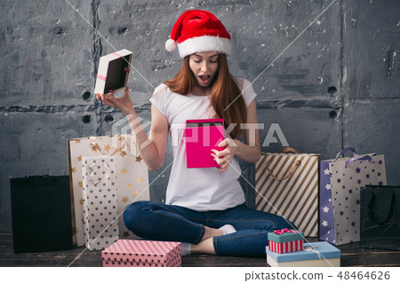 cheerful pleasant girl is looking at the pink box 48464626