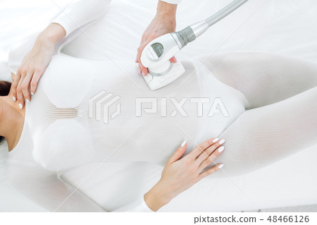 close up beauty specialist doing LPG apparatus massage on female belly close up beauty specialist doing LPG apparatus massage on female belly 48466126