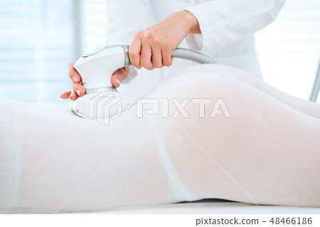Woman in white suit getting LPG procedure , body contouring treatment in clinic. Woman in white suit getting LPG procedure , body contouring treatment in clinic. 48466186