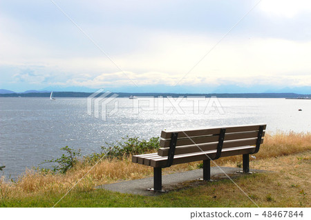 Park Bench by blue sea and sky view 48467844