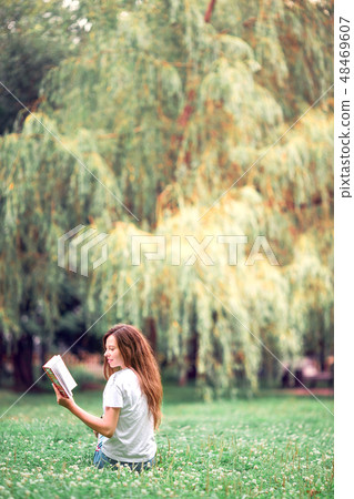 Relaxed young woman reading book 48469607