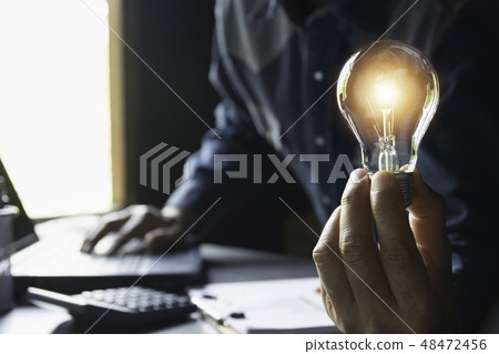 Hand of male holding a light bulb and copy space Hand of male holding a light bulb and copy space 48472456