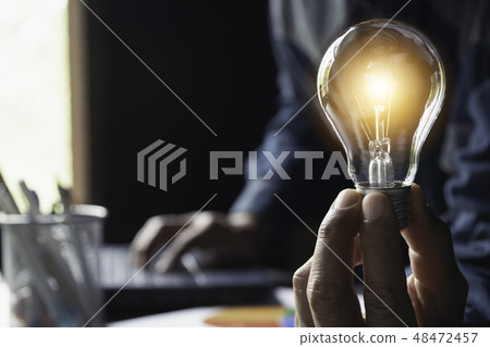Hand of male holding a light bulb and copy space Hand of male holding a light bulb and copy space 48472457