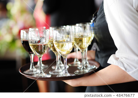 Waitress with a dish of champagne and wine glasses 48476677