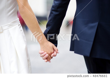 Bride and groom holding their hands 48476681