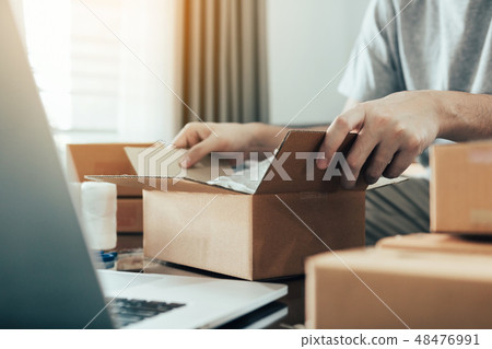 Asian entrepreneur teenager is opening a cardboard 48476991