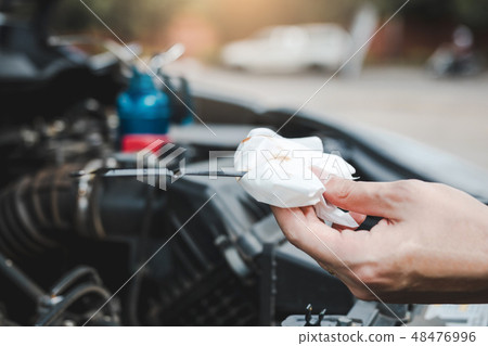 Car mechanic is checking the engine oil of the car Car mechanic is checking the engine oil of the car 48476996