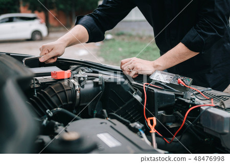 Car mechanic is checking the engine and holding Car mechanic is checking the engine and holding 48476998
