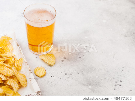 Glass of craft lager beer with potato crisps snack Glass of craft lager beer with potato crisps snack 48477163
