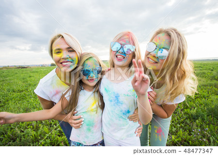 Friendship, holidays, color concept - Portrait of beautiful and happy friends covered in paint over 48477347