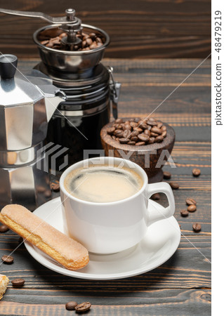 Cup of coffee with coffe maker on wooden backround Cup of coffee with coffe maker on wooden backround 48479219