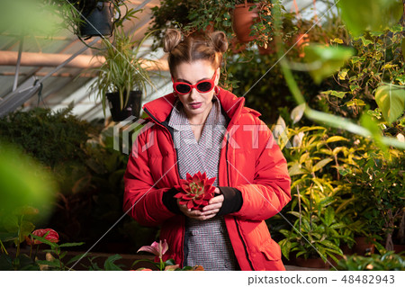 Beautiful pretty woman holding a beautiful red flower Beautiful pretty woman holding a beautiful red flower 48482943