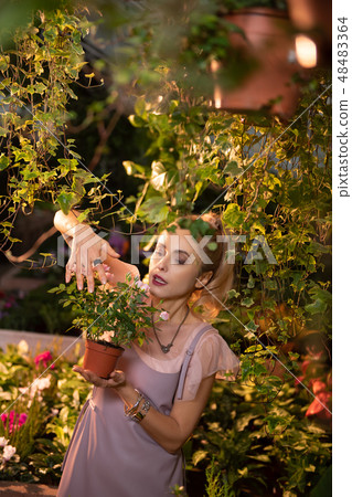 Nice attractive woman taking care of flowers Nice attractive woman taking care of flowers 48483364