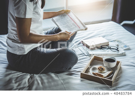 Young woman happiness on bedroom in enjoying reading books and n 48483784