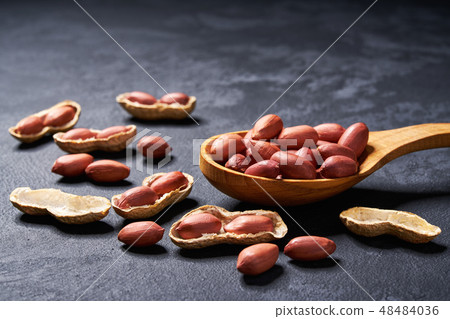 Raw peanut in wooden spoon on black table 48484036