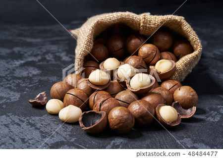 Macadamia nuts are poured out of the bag. Macadamia nuts are poured out of the bag. 48484477