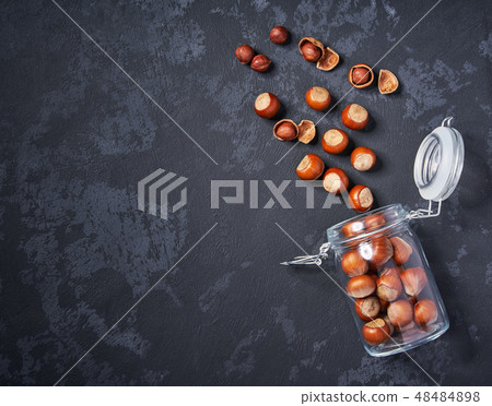 Hazelnut in an open glass jar on black table Hazelnut in an open glass jar on black table 48484898