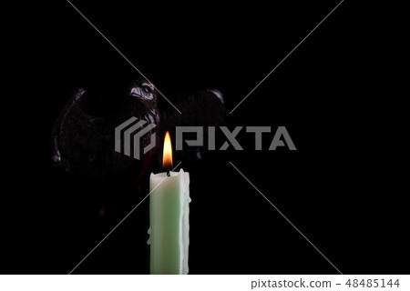 A burning pale green candle A burning pale green candle 48485144