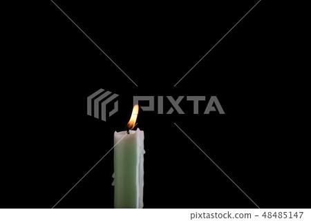 Burning pale green candle isolated on a black Burning pale green candle isolated on a black 48485147