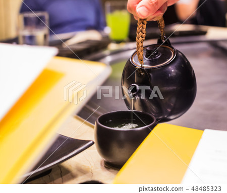 Serving Hot Herbal Matcha Green Tea from kettle 48485323