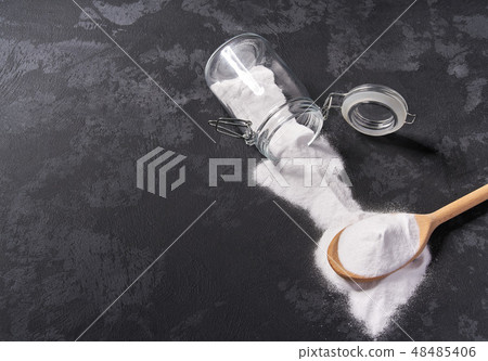 Baking soda in a wooden spoon on a black table Baking soda in a wooden spoon on a black table 48485406