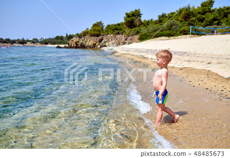 Toddler boy on beach 48485673