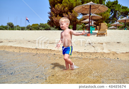 Toddler boy on beach Toddler boy on beach 48485674