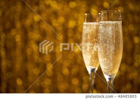 Two glasses of champagne on golden background 48485803