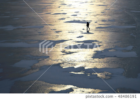 Silhouette of a man walking on the ice. 48486191